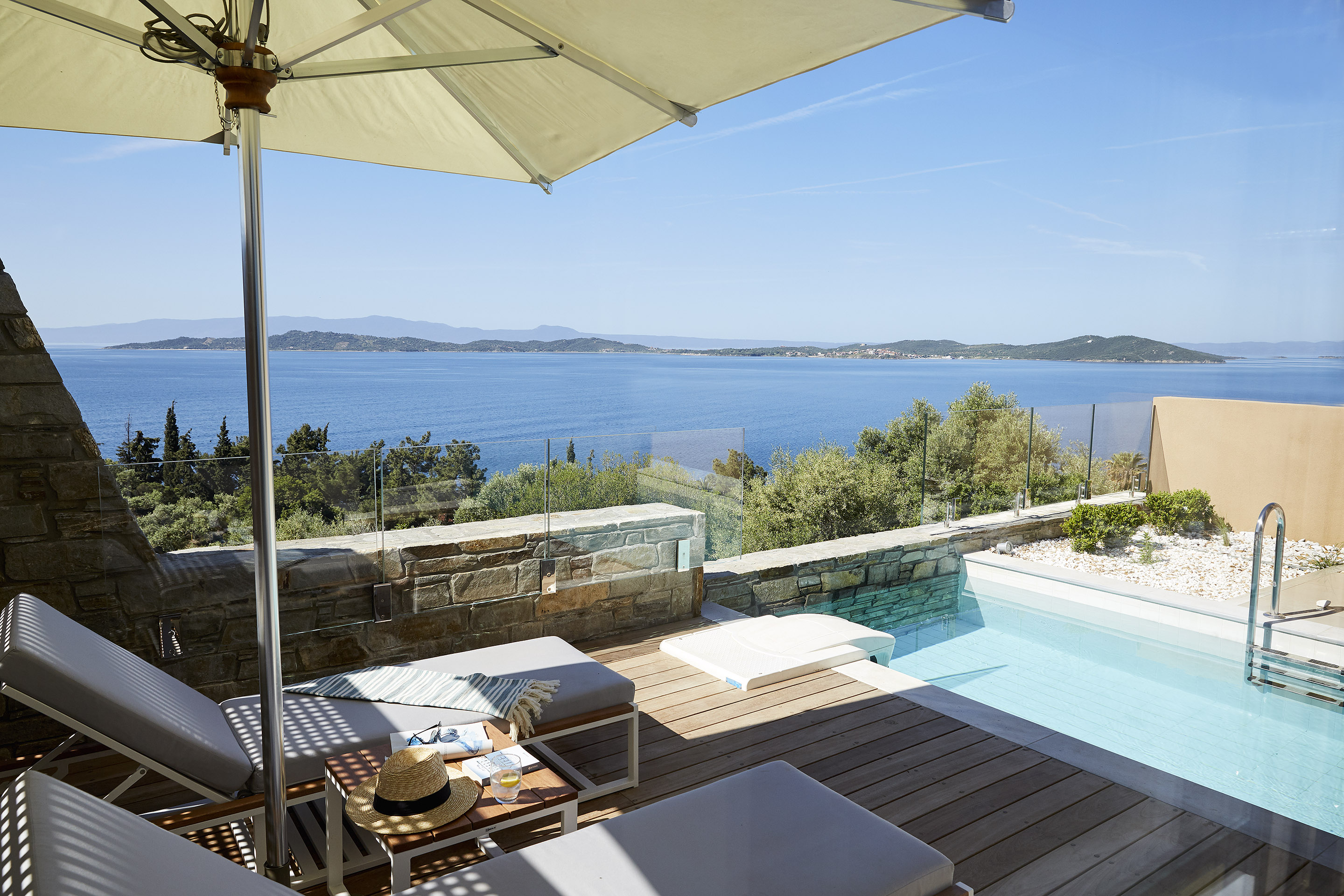 
Two bedroom villa's private pool area, with sun loungers under umbrella and panoramic sea view at Eagles Villas