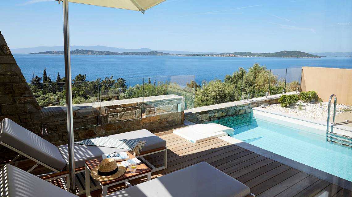 Two bedroom villa's private pool area, with sun loungers under umbrella and panoramic sea view at Eagles Villas