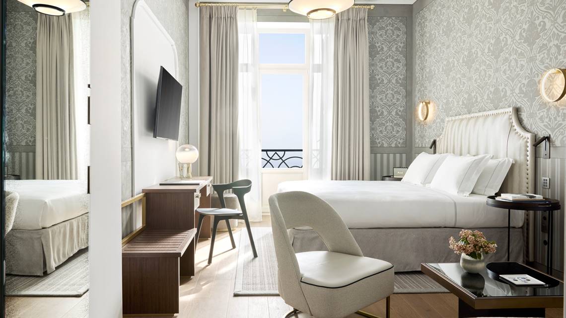 Junior suite seafront with balcony, elegant bed, seating area, desk and sea view at ON Residence Hotel