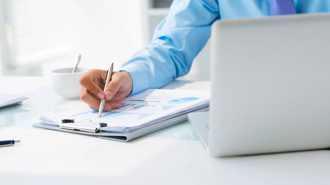 Businessman reviewing financial charts and reports during feasibility study and business planning