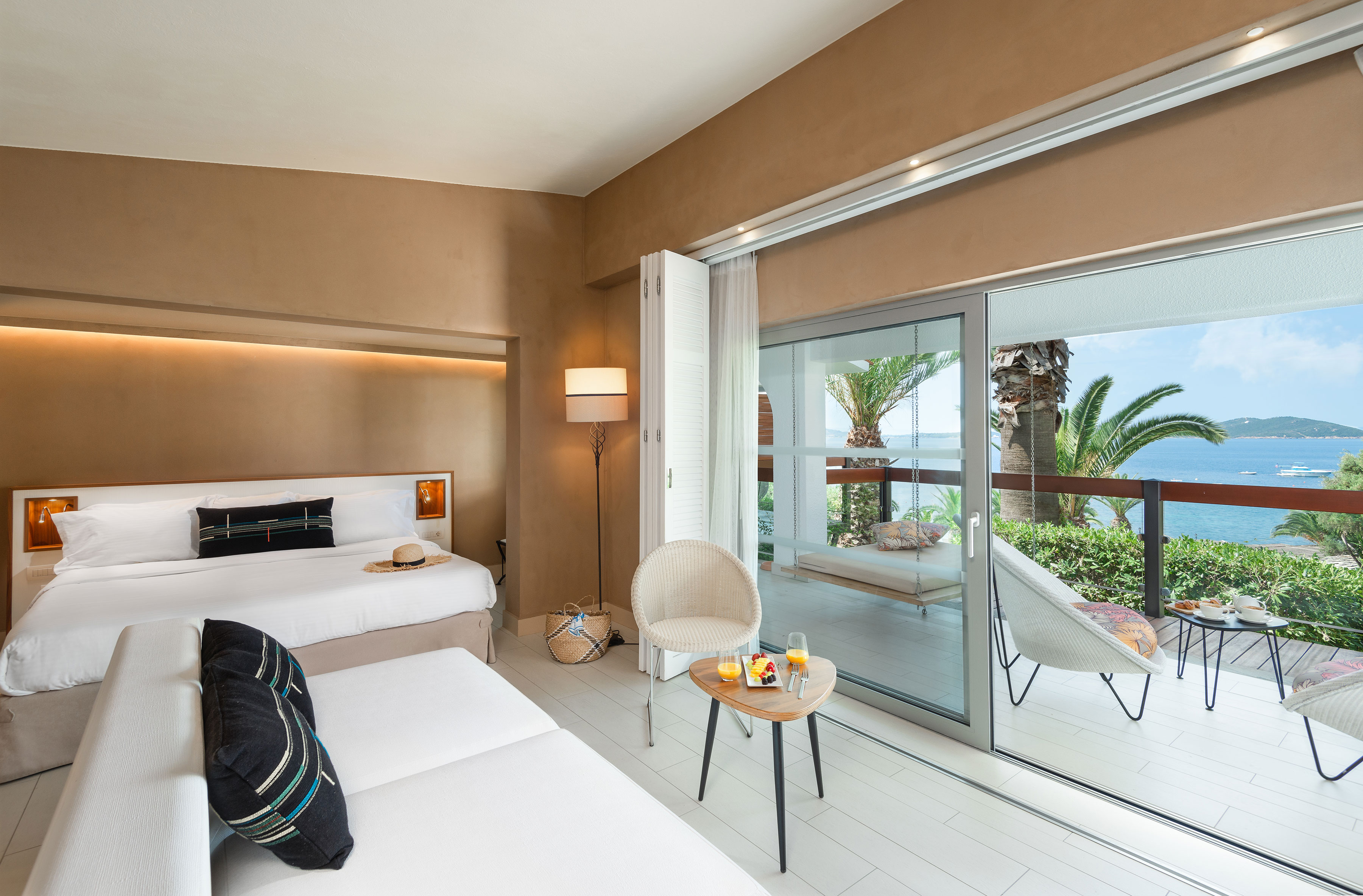 
Elegant bungalow interior with sea view, king-size bed, lounge area and furnished balcony at Eagles Palace