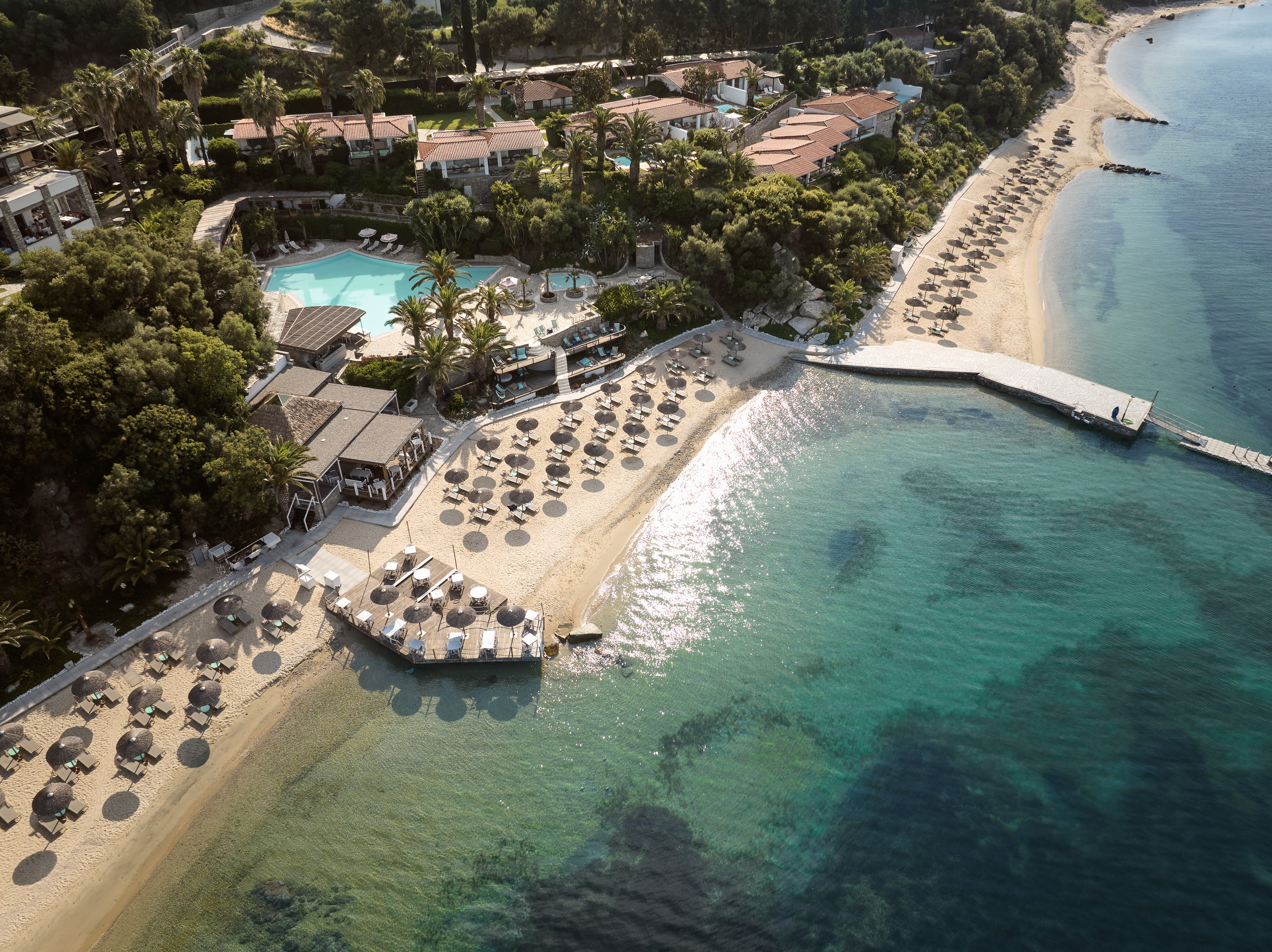 
Aerial view of Eagles Resort, sandy beach with trees and umbrellas, and swimming pool